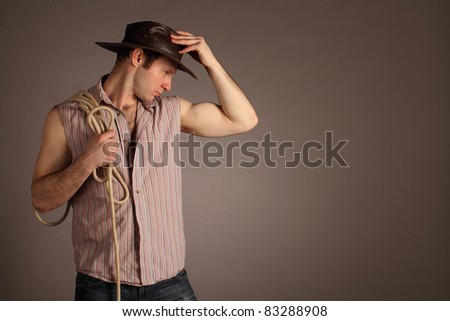 Cowboy with hat and lasso. Studio shot