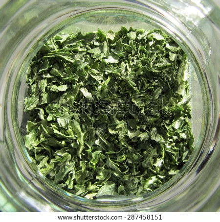 Glass jar with dried parsley (close up).