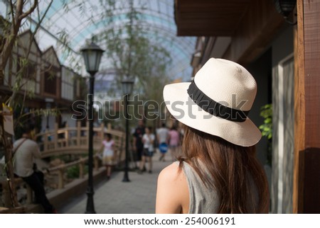 Back side of women wear hat at the shopping street