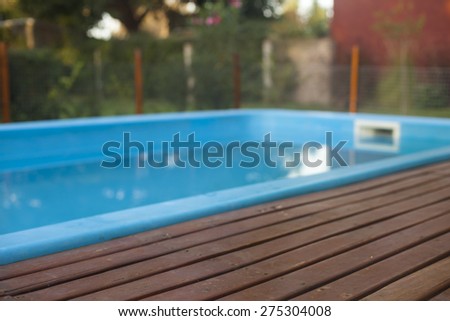 residence with swimming pool and deck. Surrounded by fence