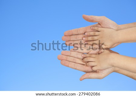 father and son holding hands on a blue sky background