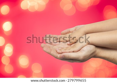 father and son holding hands on red christmas lights background