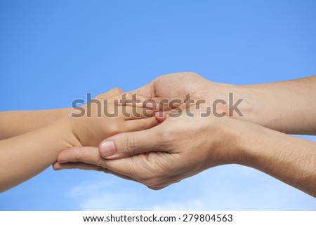 father and son holding hands on sky with clouds background