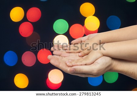 father and son holding hands on multicolored christmas lights background