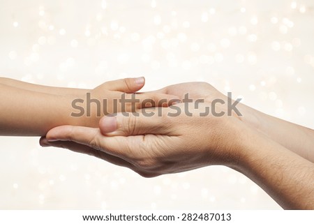 father and son holding hands on beautiful christmas lights background