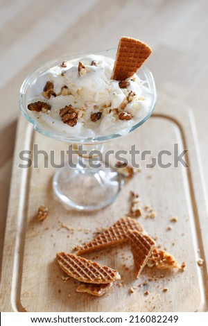 white ice cream with waffle and nuts on the cutting board