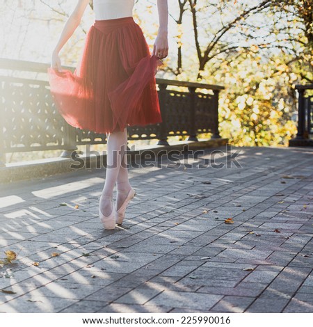 ballet dancer dancing in the park. Main focus on her legs