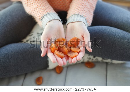 handful of dried apricots. Woman holding dried apricots.
