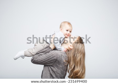 Mother playing with baby girl, happy family having fun indoor, mom and child isolated on white background.