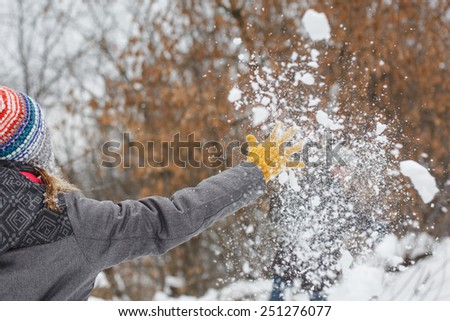 woman in yellow gloves catching a snowflake outdoors