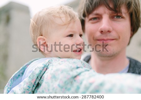 Father holds a cute crying baby on his hands
