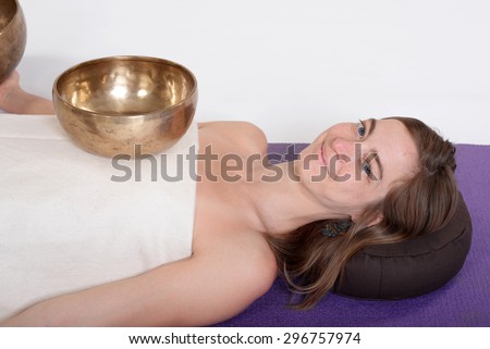 Young beautiful healthy girl receiving energy sound massage by a healthy sound therapist.