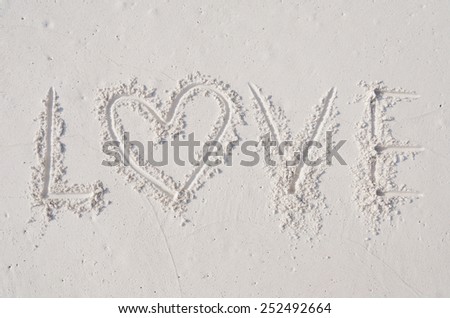 finger drawing on sandy beach love , word of love.