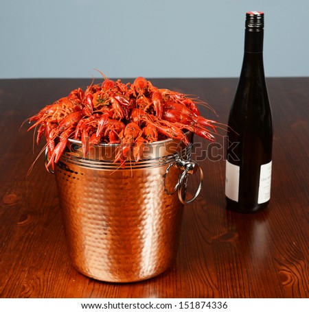 silver bucket of boiled crawfish served with wine