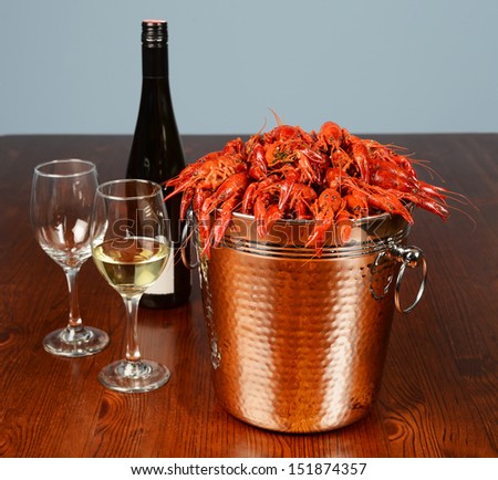 bucket full of river lobsters served with wine and glasses