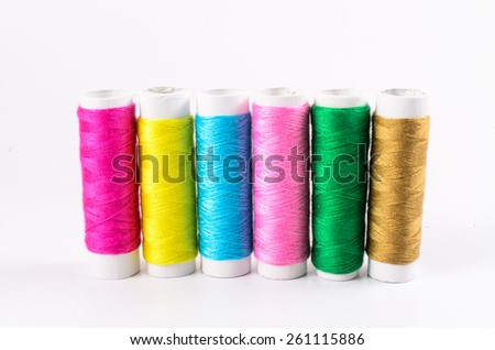 multicolor sewing threads on white background, spools of threads