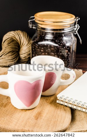 Two coffee cup on wooden board and coffee bottle with back background