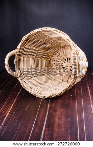 Empty wicker basket on wooden board