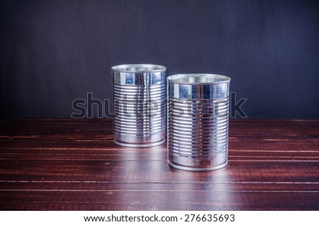 empty food tin can on wooden board background