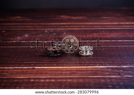 old sewing machine bobbins on wooden background