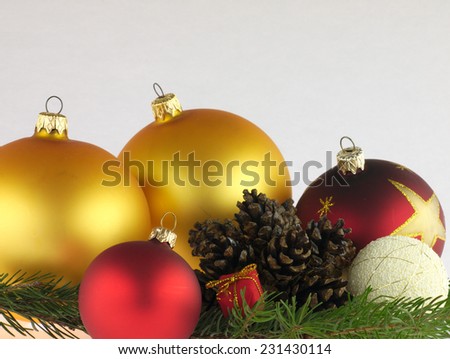 Red and gold Christmas balls on pine twig with a pine cones.