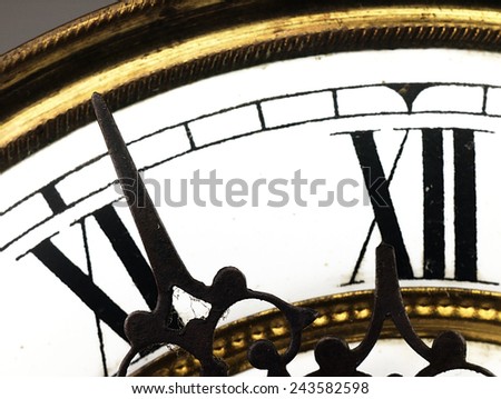 Mechanism of old clock. Clock face and hands showing five minutes to midnight.