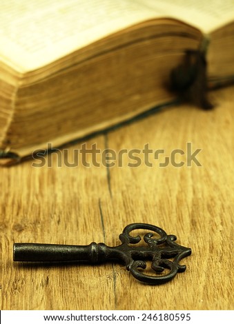 Old book with a damaged cover and key. Book is open, visible texture sheets.