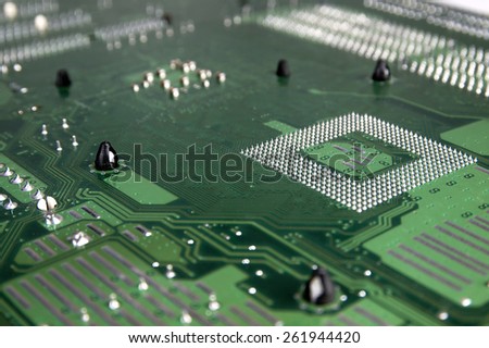 Close up of the surface of an old computer motherboard. Visible electrical path.
