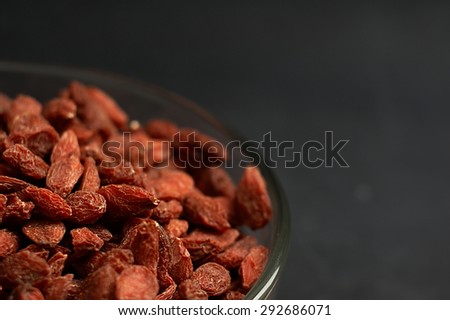 Goji berries in a bowl on the table. Shallow depth of field.