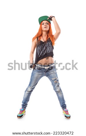 Modern hip-hop dance girl hold on to the sun visor cap on white background. Young teenager swag style with jeans, cap and fingerless gloves