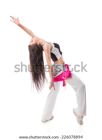 Young modern flexible hip-hop dance girl bends backwards with hanging hair. Female in white sweatpants and a pink hoodie and sneakers standing on isolated white background.