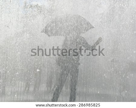 Person with umbrella in a rain downpour.