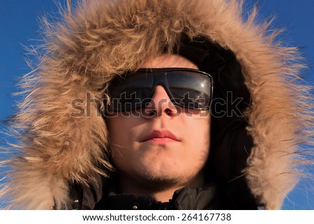 Man with sunglasses looking at the horizon on blue sky background