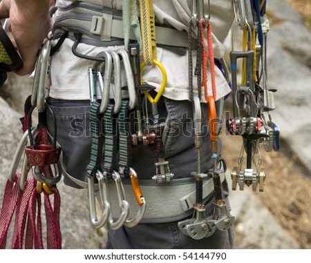 Collection of rock climbing gear attached to a climber\'s harness