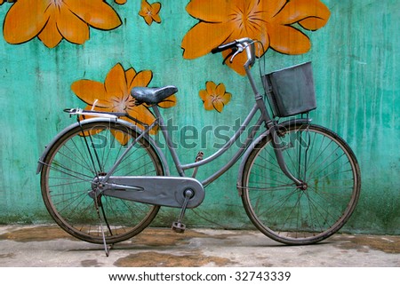 stock photo Old bike with a basket against a colourful wall