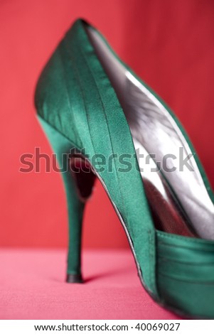 One green stiletto high heel shoe.