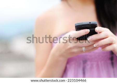 A young girl is gaining on the cell phone. She wants to call someone or get SMS. It is wearing a gorgeous purple dress. It was shot very close up