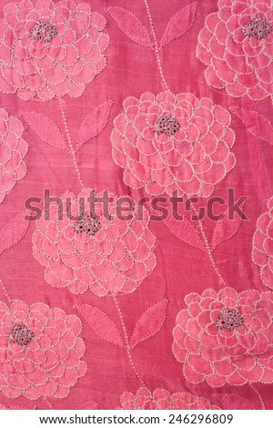 Intricate flowers embroidered on a deep pink fabric. White flowers. Handmade.