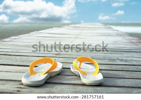 Shoes on wooden walkway. Blue sky in backgrounds.