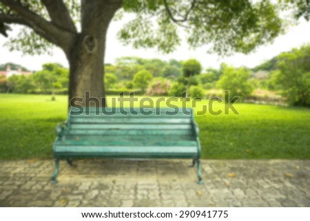 Blurry image.  Old green bench in the park