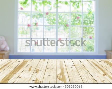 Wood table top on window interior room blurred background.