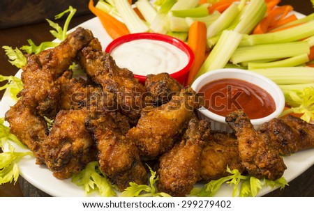 platter of hot and spicy chicken wings with veggie sticks