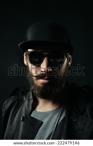 The close-up portrait of brutal bearded man in a black fitted hat