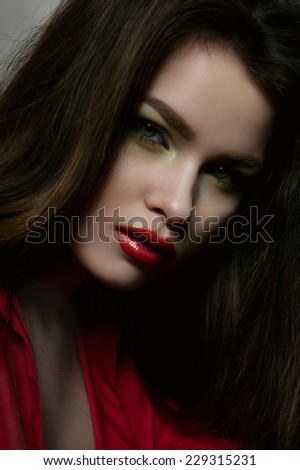 Beauty fashion female brunette model with red lips and red blouse
