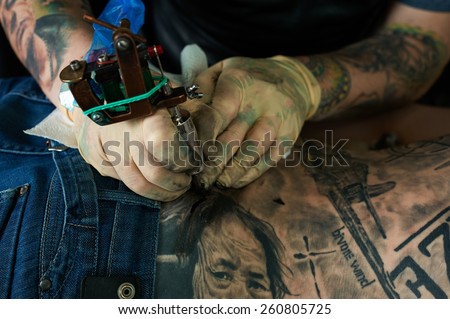 Working hands of tattoo master. Closeup