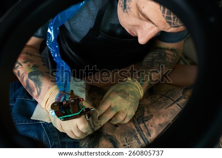 Tattoo artist working in studio. Closeup