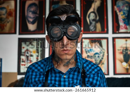 Closeup portrait of tattooed man in welder glasses