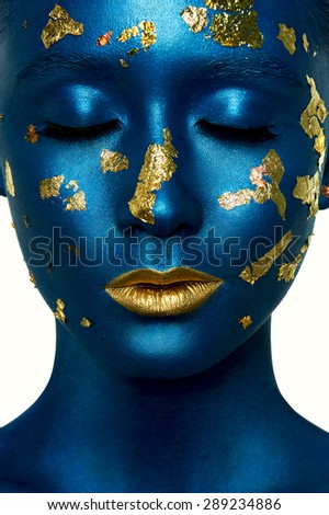 Beauty fashion Girl with closed Eyes, blue Paint on Skin and gold Lips. Halloween Alien Makeup