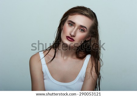 Beauty fashion Model with perfect Skin, wet Hair and dark red Lips
