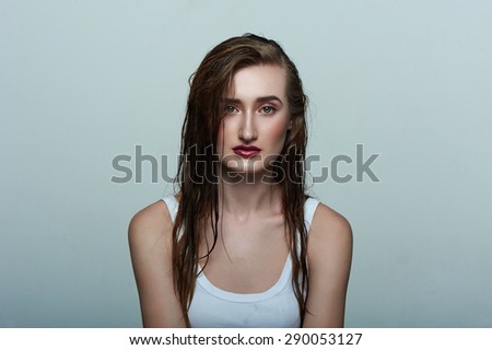Beauty female Model with perfect Skin, wet Hair and dark red Lips